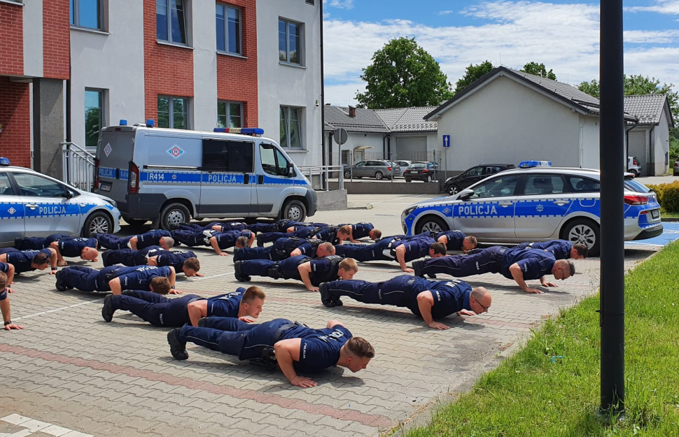 Policjanci robią pompki przed budynkiem komendy w Bieruniu
