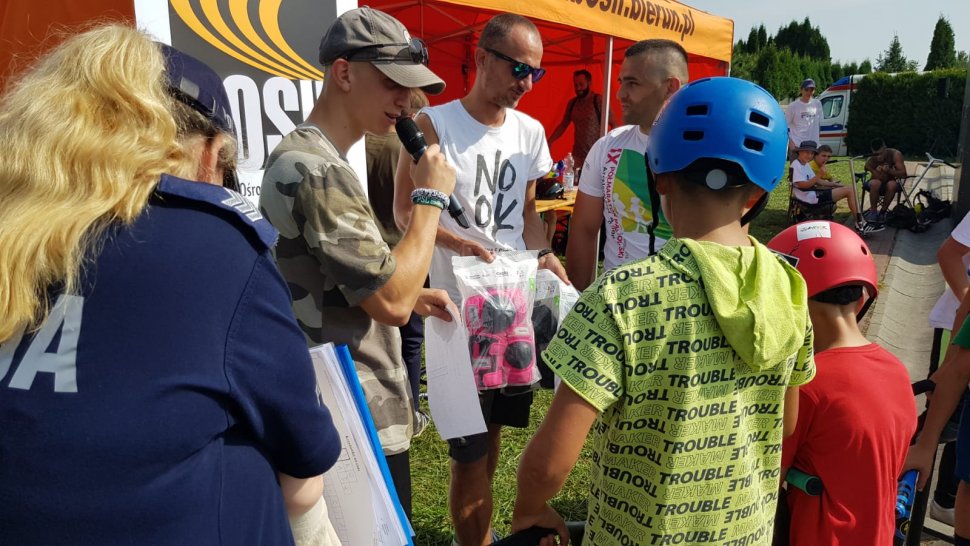 Skatepark w Bieruniu, policjantka i organizatorzy z BOSiRU wręczają dzieciom nagrody.