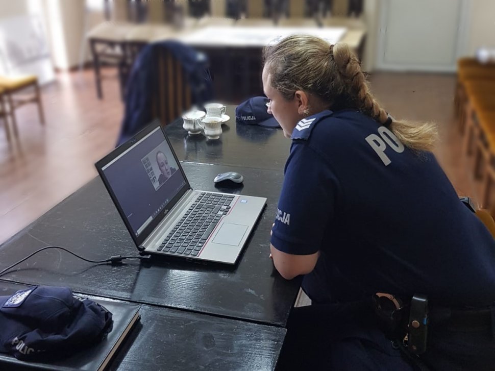 Policjantka siedzi przed laptopem i prowadzi prelękcję online