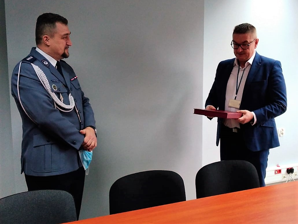 W pomieszczeniu Komendy Powiatowej Policji w Bieruniu po lewej stoi komisarz Dariusz Waligóra, po prawej odchodzący na emeryturę aspirant sztabowy Jakub Momot