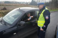 Policjant wręcza kierowcy serduszko kampanii &quot;stop wariatom drogowym&quot;