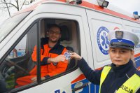 Policjantka wręcza kierowcy karetki pogotowia serduszko kampanii Stop wariatom drogowym