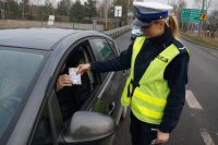 Policjantka wręcza kierowcy serduszko kampanii Stop wariatom drogowym