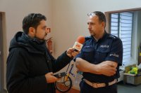 Policjant udziela wywiadu dziennikarzowi radia eM