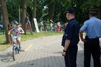 Policjant, strażnik miejski i dziecko na rowerze