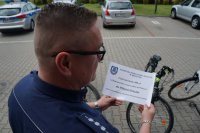 Naczelnik Wydziału Prewencji trzyma symboliczny czek