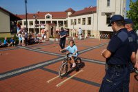 Strażnicy miejscy, policjant i uczestnik olimpiady na rowerowym torze przeszkód