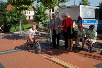 Uczestnik olimpiady na rowerowym torze przeszkód. W tle Senator RP - Czesław Ryszka i Burmistrz Miasta Lędziny - Krystyna Wróbel