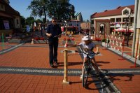 Policjant i uczestnik olimpiady na rowerowym torze przeszkód