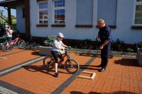 Policjant i uczestnik olimpiady na rowerowym torze przeszkód