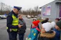 Policjant i dzieci podczas akcji &quot;Bezpieczna rodzina na drodze&quot; w Lędzinach