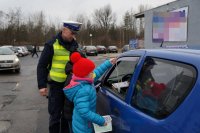 Policjant i dzieci podczas akcji &quot;Bezpieczna rodzina na drodze&quot; w Lędzinach