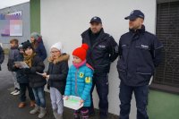 Policjanci i dzieci podczas akcji &quot;Bezpieczna rodzina na drodze&quot; w Lędzinach