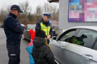 Policjanci i dzieci podczas akcji &quot;Bezpieczna rodzina na drodze&quot; w Lędzinach