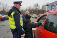 Policjant i dzieci podczas akcji &quot;Bezpieczna rodzina na drodze&quot; w Lędzinach