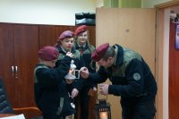 Harcerze przekazują policjantom Betlejemskie Światło Pokoju