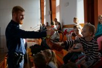 Dzielnicowy mł. asp. Kornel Kulas częstuje dzieci cukierkami
