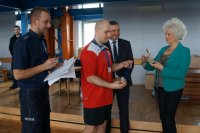 Dzielnicowi asp. Daniel Laszczak i mł. asp. Michał Mamoń wręczają podziękowania za organizację turnieju Burmistrz Miasta Lędziny - Pani Krystynie Wróbel. Na drugim planie dyrektor KWK Piast-Ziemowit Ruch Ziemowit