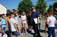 Policjant stoi na boisku z dziećmi