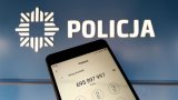 Telefon komórkowy, w tle logo Policji