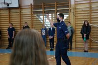 Policjant na uroczystym apelu na sali gimnastycznej