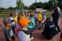 Policjanci przeprowadzają pogadankę z grupą dzieci