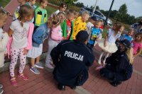 Policjanci przeprowadzają pogadankę z grupą dzieci