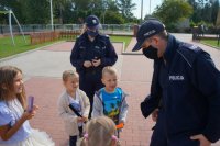 Policjanci przeprowadzają pogadankę z grupą dzieci