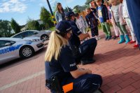 Policjanci przeprowadzają pogadankę z grupą dzieci