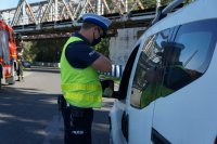 Działania Road Safety Days na DK44 w Bieruniu, policjant stoi przy zatrzymanym do kontroli drogowej samochodzie