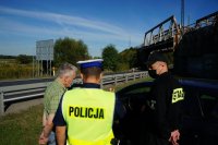 Działania Road Safety Days na DK44 w Bieruniu, policjant i strażak udzielają instruktażu mężczyźnie