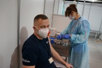 Policjant w gabinecie oczekuje na szczepienie