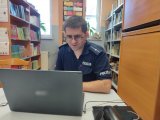 policjant prowadzący profilaktykę przez komputer