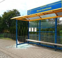 Wiata przystanku z wybitą szybą. Na chodniku leży potłuczone szkło