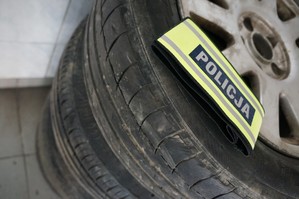 Koło z samochodu na którym leży opaska z napisem POLICJA