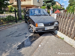 Czarny samochód, który wjechał w ogrodzenie, widok z przodu. Spod pojazdu wyciekł płyn. Autor zdjęcia: portal 112Tychy