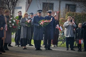 Policjanci oczekują z wieńcem przed pomnikiem