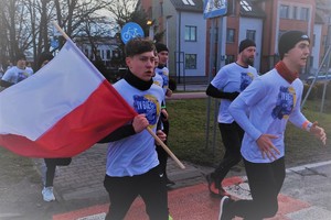 Zdjęcie biegnącej młodzieży. Z tyłu widać budynek komendy Policji w Bieruniu