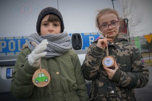 Zdjęcie: dwie dziewczynki pozują do zdjęcia trzymając zawieszki dla kierowców