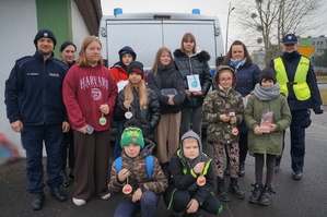 Zdjęcie do którego pozują dzieci, opiekunki  i policjanci
