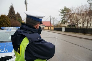 Na zdjęciu widać policjanta, który mierzy prędkość poruszających się samochodów.