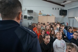 Na zdjęciu widzimy policjanta oraz uczniów z którymi była przeprowadzana profilaktyka