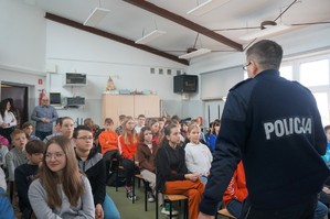 Na zdjęciu widzimy policjanta oraz uczniów z którymi była przeprowadzana profilaktyka