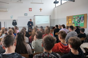 Na zdjęciu widzimy policjanta oraz uczniów z którymi była przeprowadzana profilaktyka