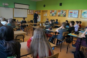 Na zdjęciu widzimy policjanta rozmawiającego z uczniami