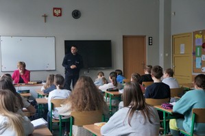 Na zdjęciu widzimy policjanta rozmawiającego z uczniami