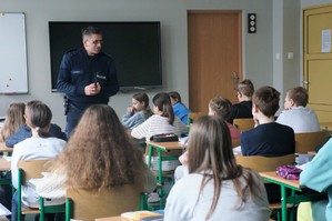Na zdjęciu widzimy policjanta rozmawiającego z uczniami