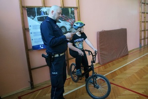 Na zdjęciu widzimy policjanta wraz z uczestnikami Powiatowego Turnieju Bezpieczeństwa w Ruchu Drogowym