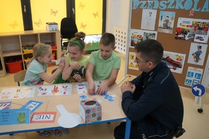 Na zdjęciu widzimy dzieci biorące udział w konkursie oraz policjanta