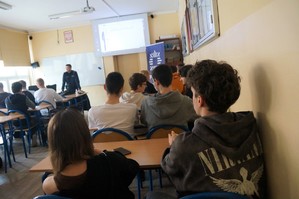 Na zdjęciu widzimy policjanta omawiającego z uczniami rekrutację do Policji
